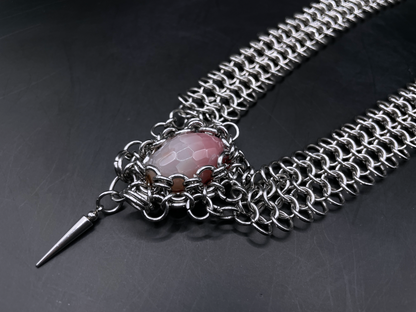 Chainmail necklace with a pink stone and spike on a dark background